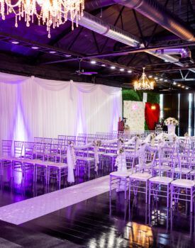 A large room filled with chairs and a purple chandelier.