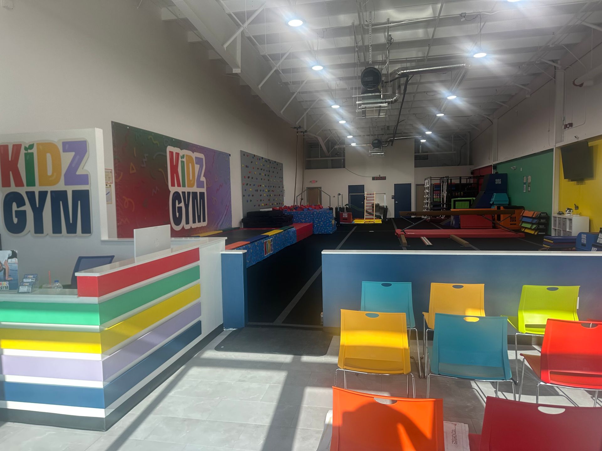 Exterior of Kidz Gym with colorful sign and awning, daytime.