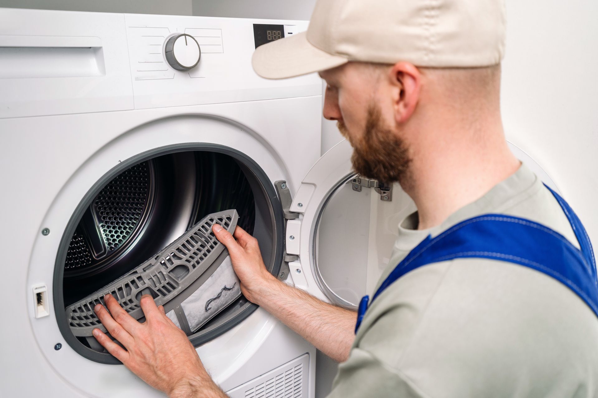 Man repairing the drum inside a front-loading washing machine with the door open