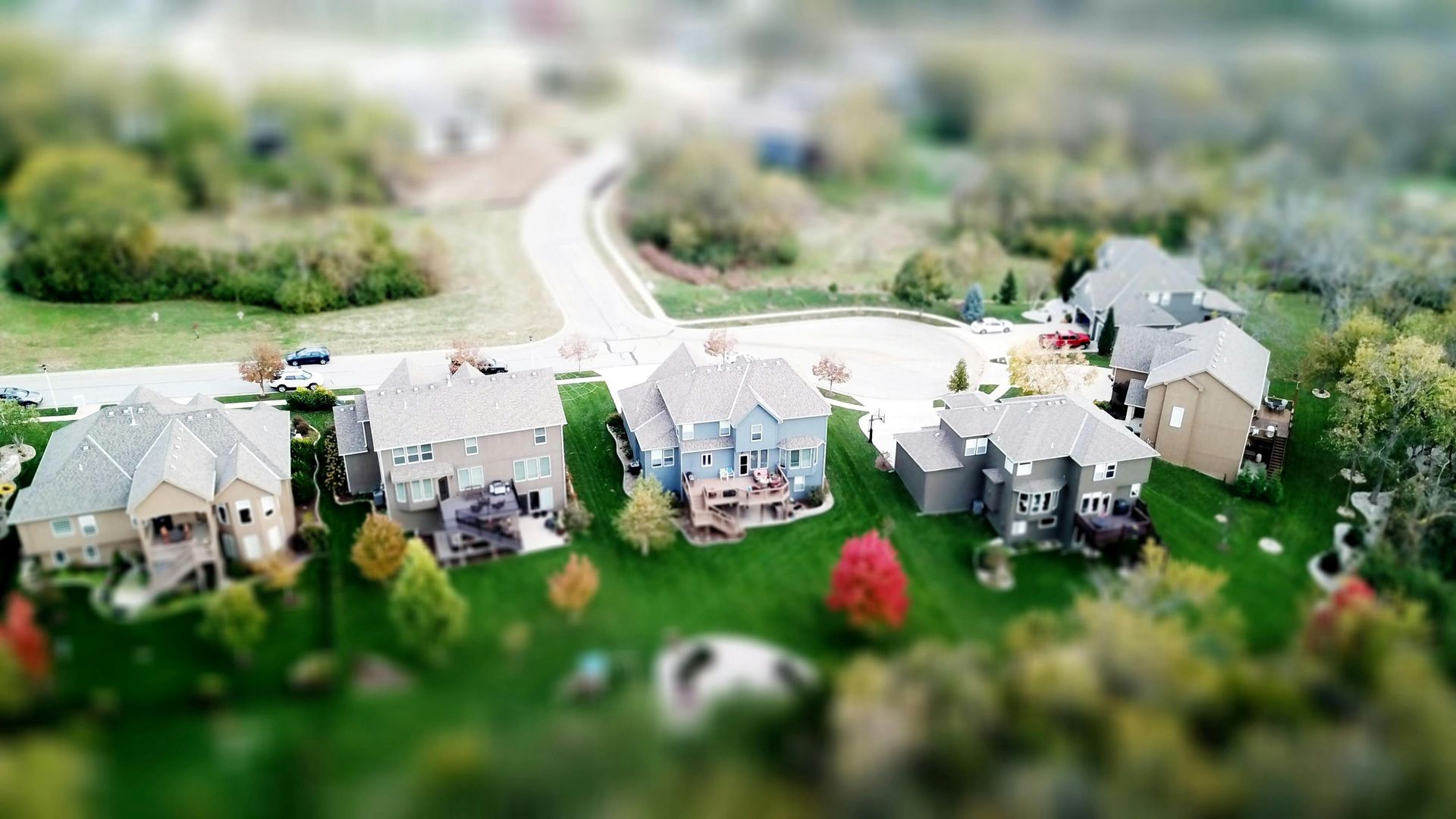 Aerial view of a small suburban neighborhood with houses along a winding road.