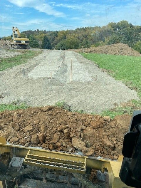Yellow excavator on a dirt mound, scooping earth under a blue sky. Yellow excavator on a dirt mound, scooping earth under a blue sky.