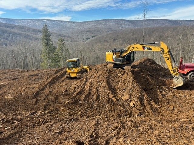 Truck being loaded with concrete cylinders by an excavator, construction site. Truck being loaded with concrete cylinders by an excavator, construction site.