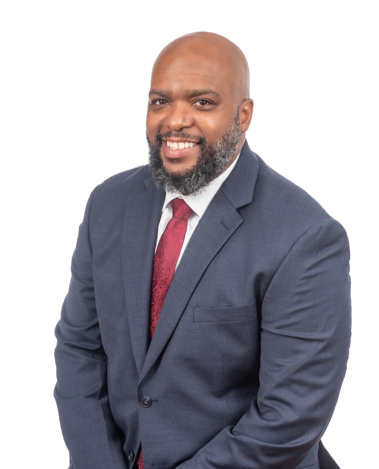 Man in a blue suit and red tie smiles, posing against a white background.