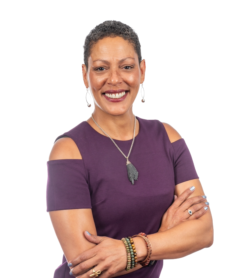 Woman with short hair, smiling, wearing a purple dress, arms crossed.