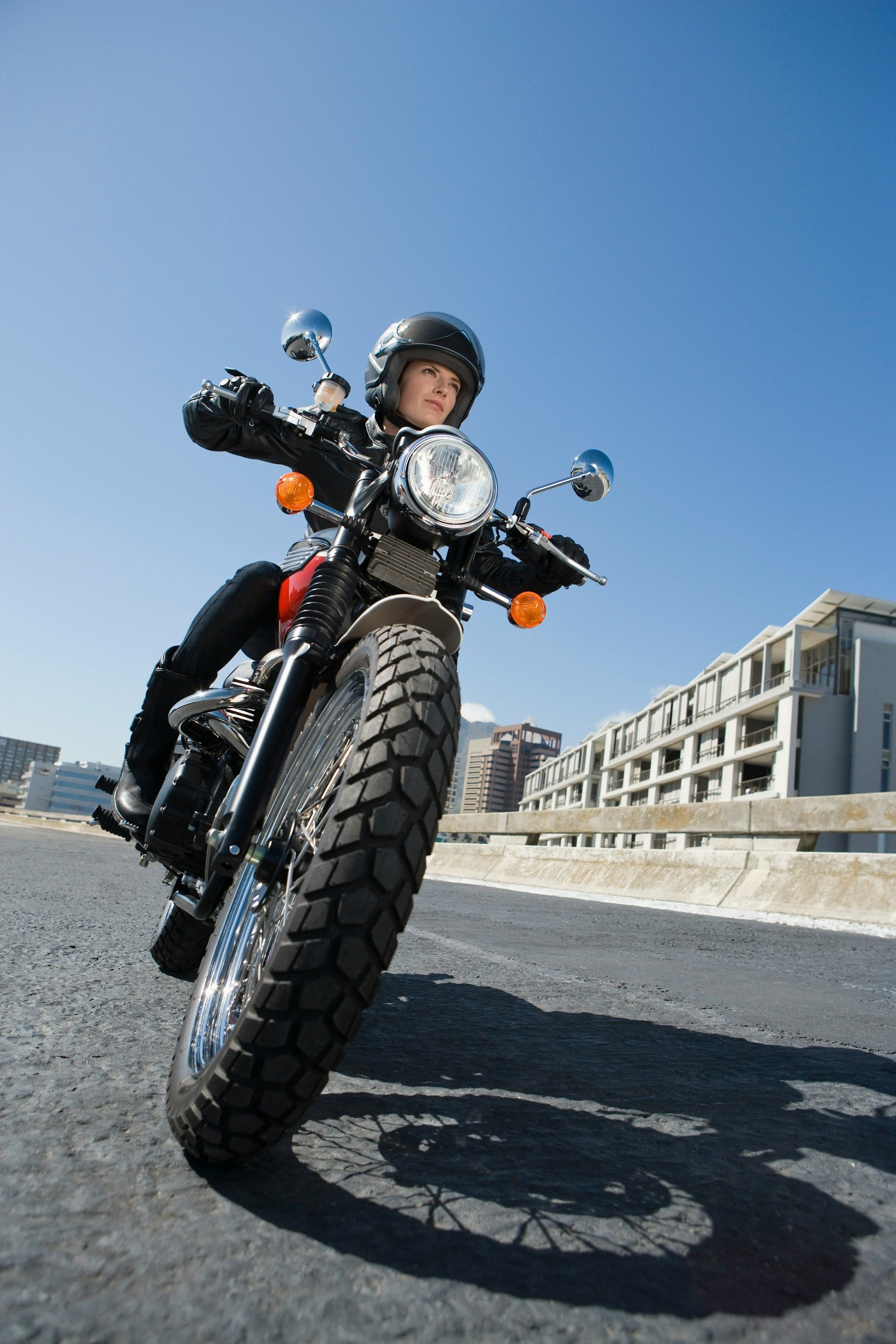 Person riding a black motorcycle on a sunny road.