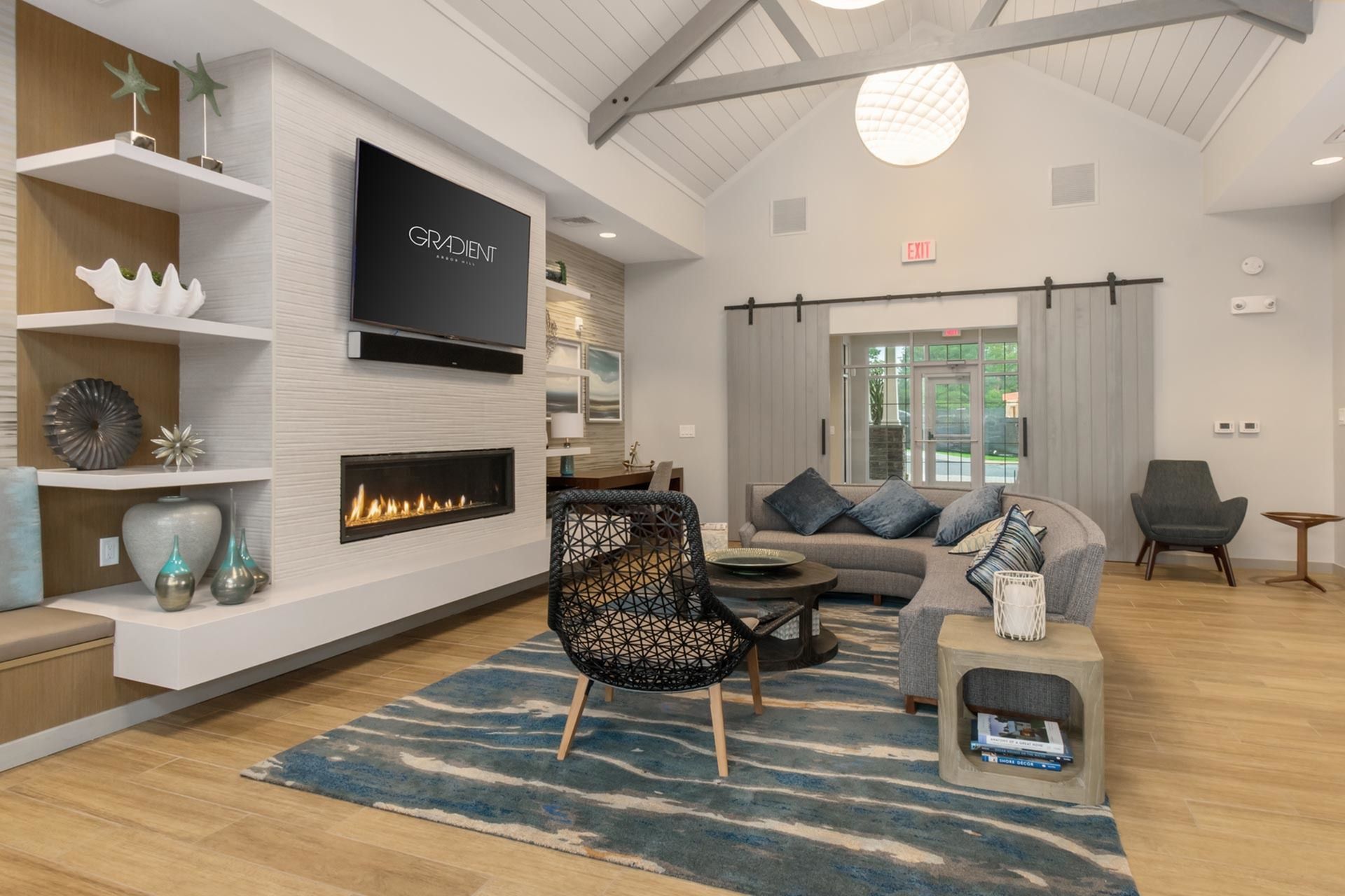 Gradient luxury clubhouse featuring a digital fireplace, plush sofas, elegant rugs, and a state-of-the-art TV.