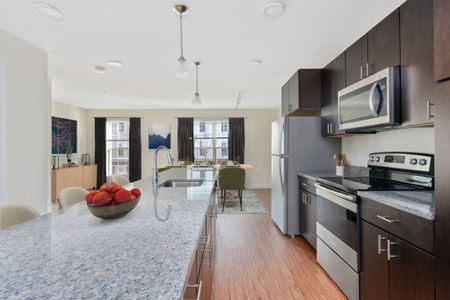 Gradient apartment's modern kitchen with oversized island and modern kitchen cabinets. 