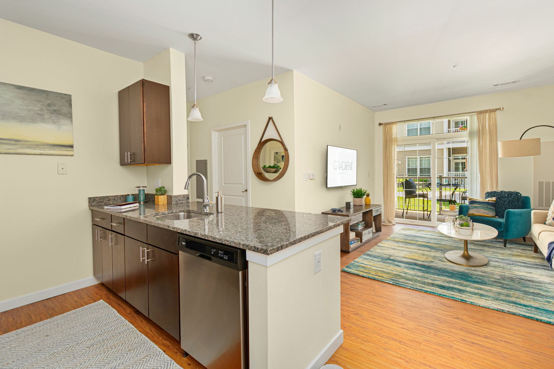 Gradient apartment open floor plan with kitchen overlooks the apartment living room and balcony.