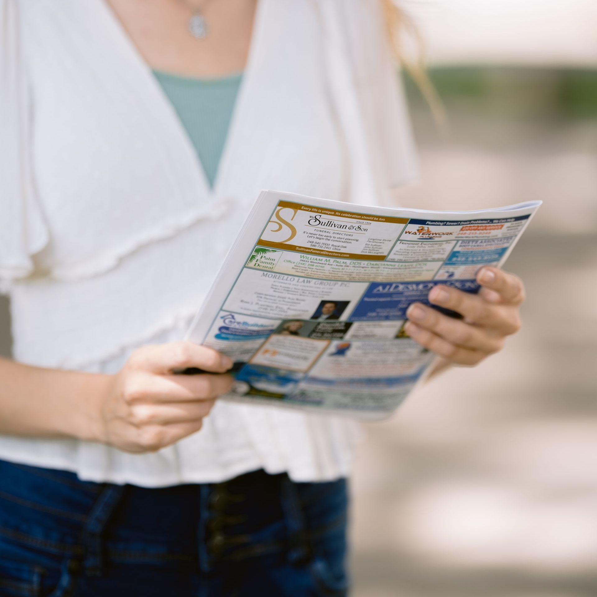 Person holding and reading a colorful brochure outdoors