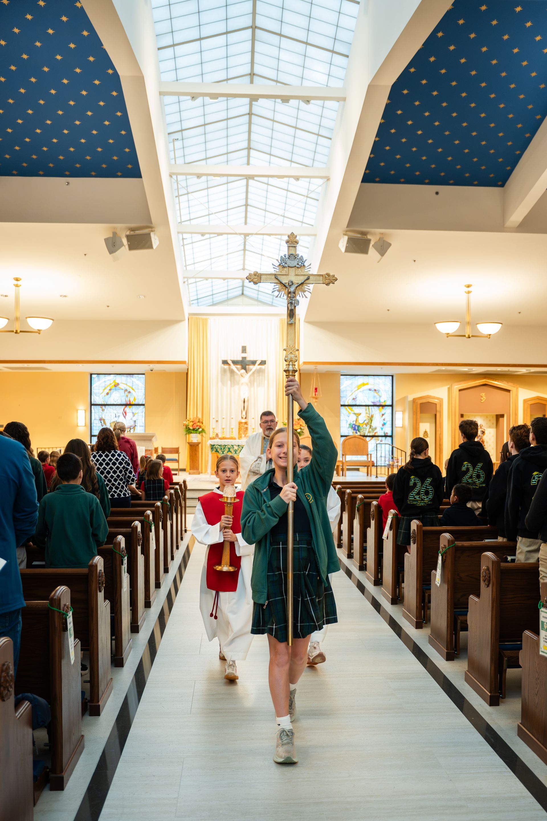 Person carrying a cross down an aisle in a church procession