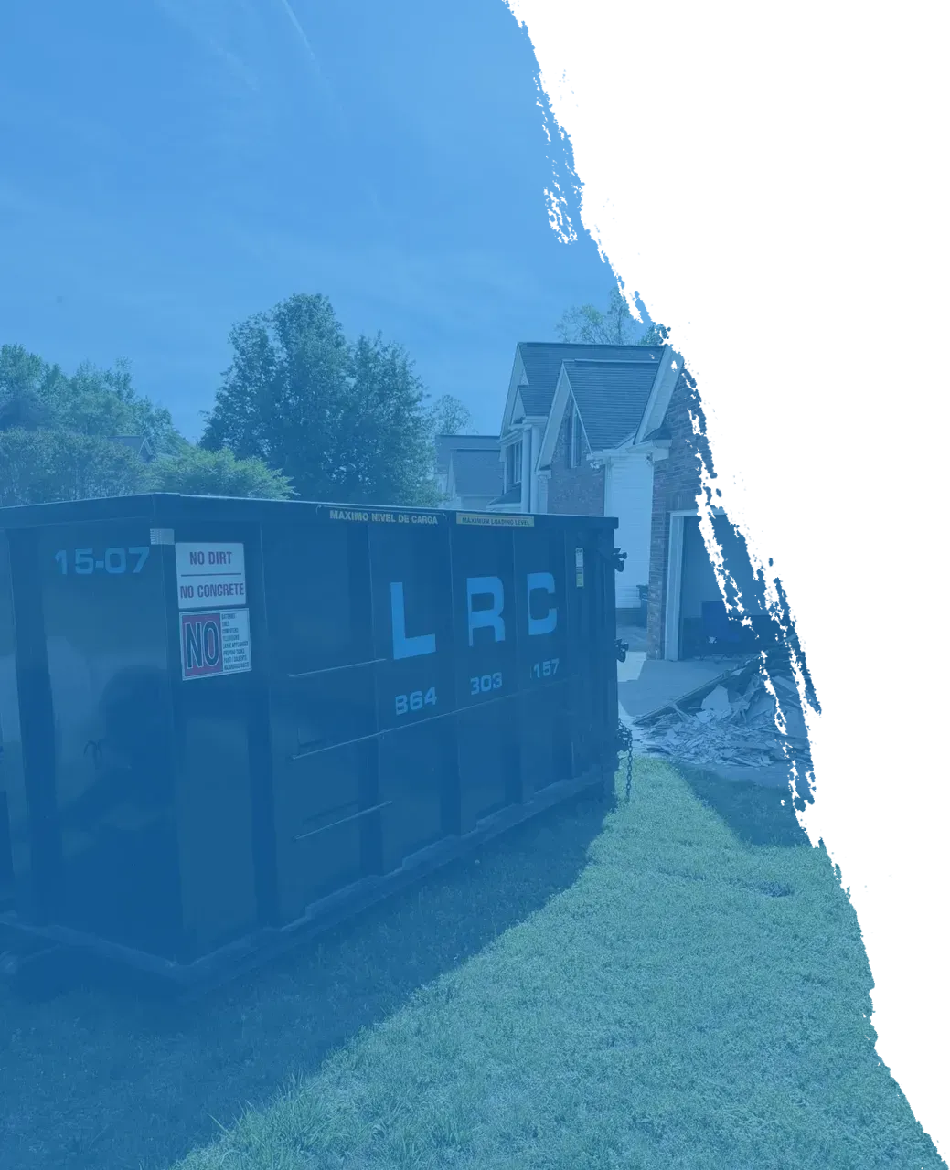 Roll off dumpster on a driveway with protective barrier in place