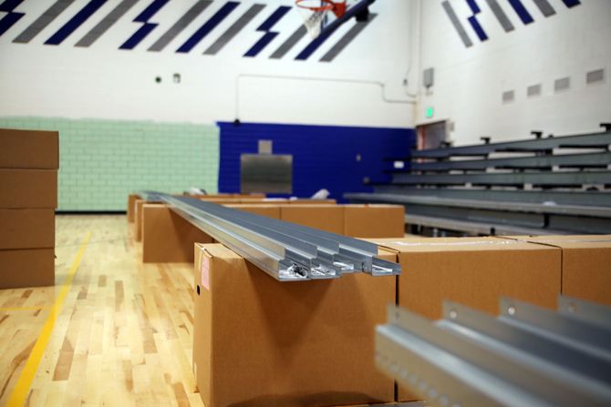 Metal nose beams are staged upon boxes for quick and efficient installation by Kalamazoo Seating Service Group.