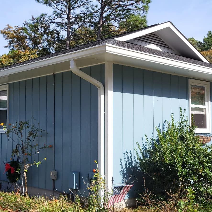 a blue house with a white gutter on the side