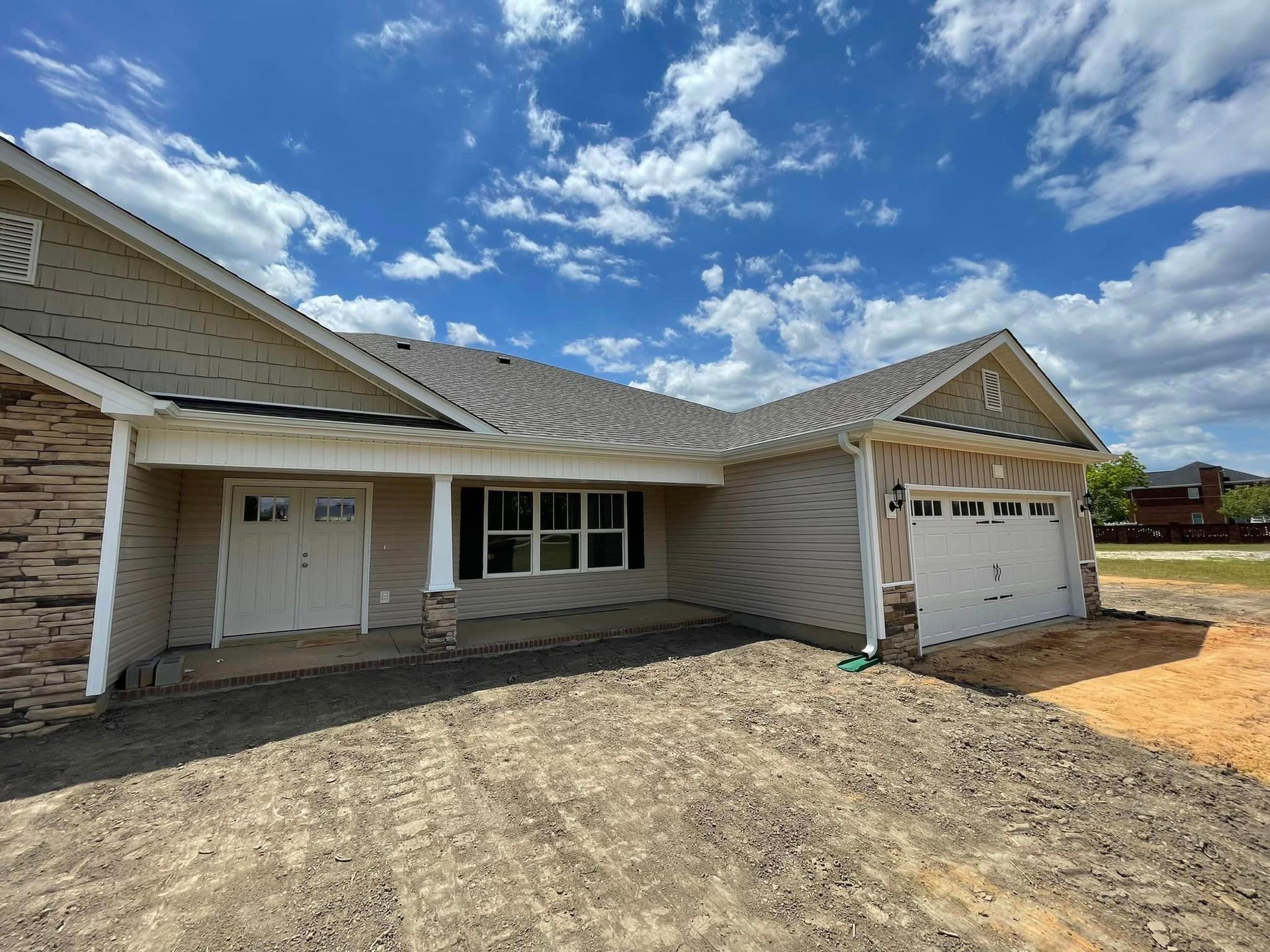 the front of a house with a garage and a porch showing that gutters are needed