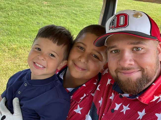 Steven from SNL Seamless Gutters is sitting with his sons in a golf cart.