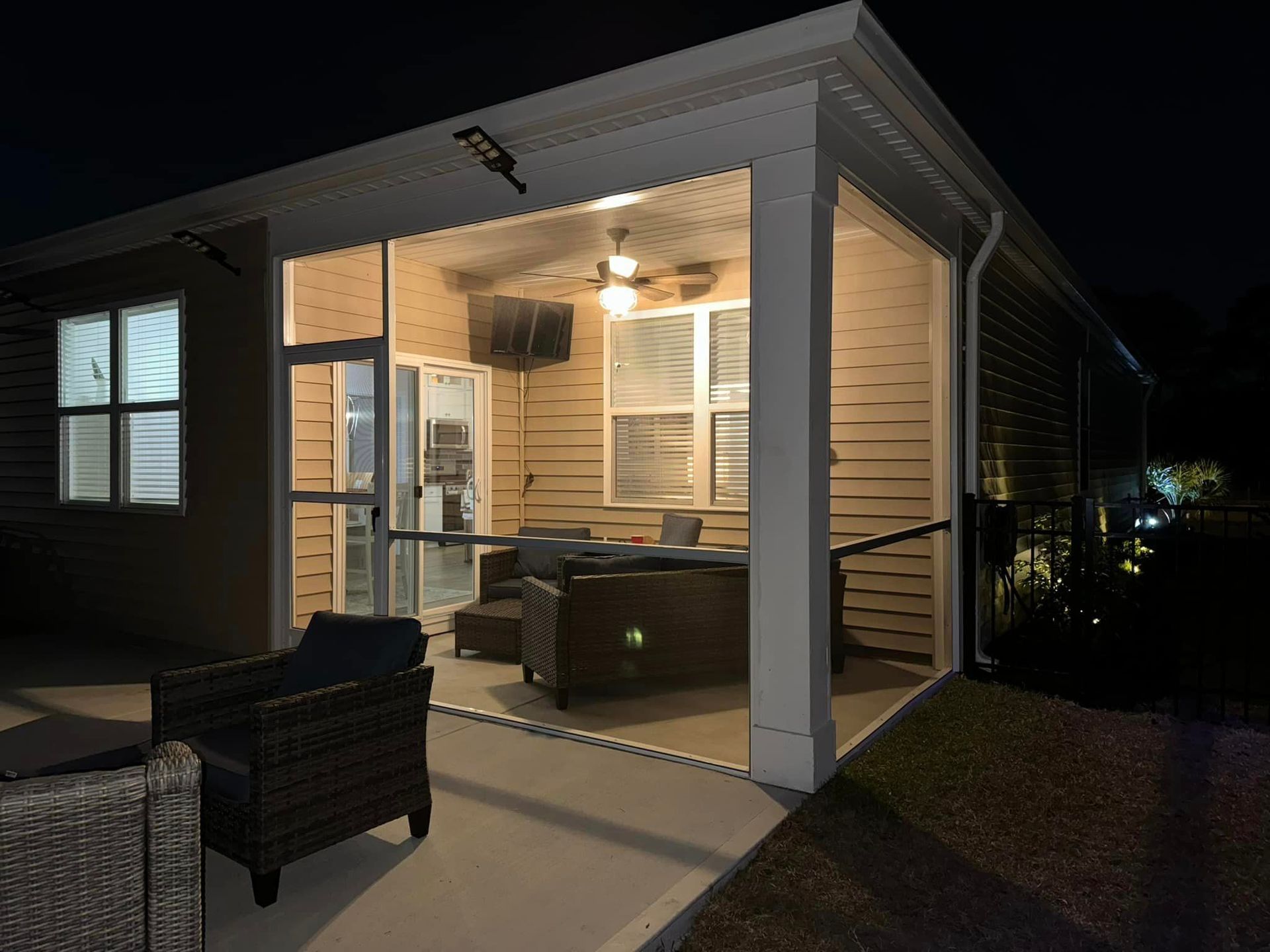 a screened in porch is lit up at night installed by SNL seamless gutters