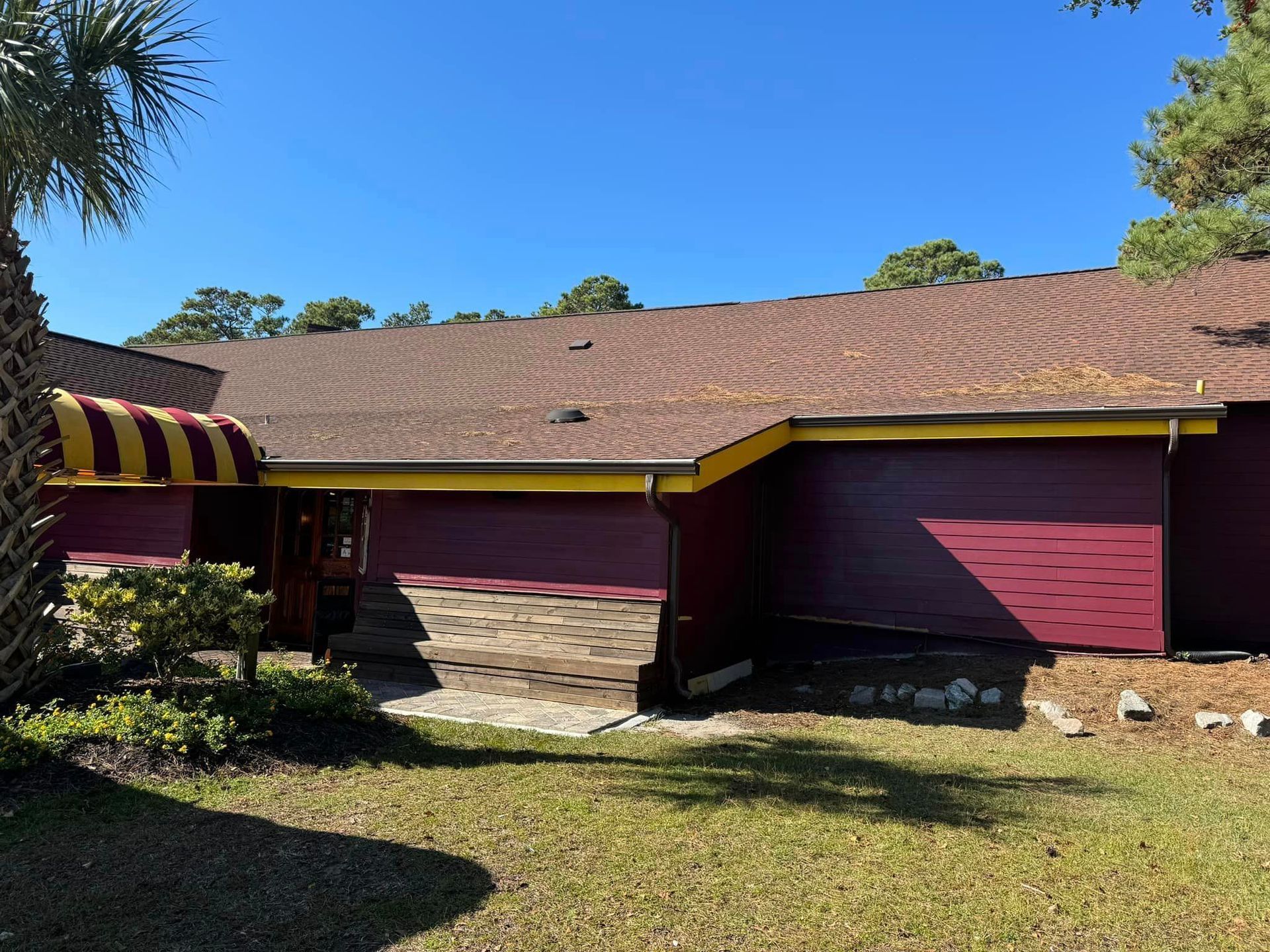 a red house with brown rain gutters installed