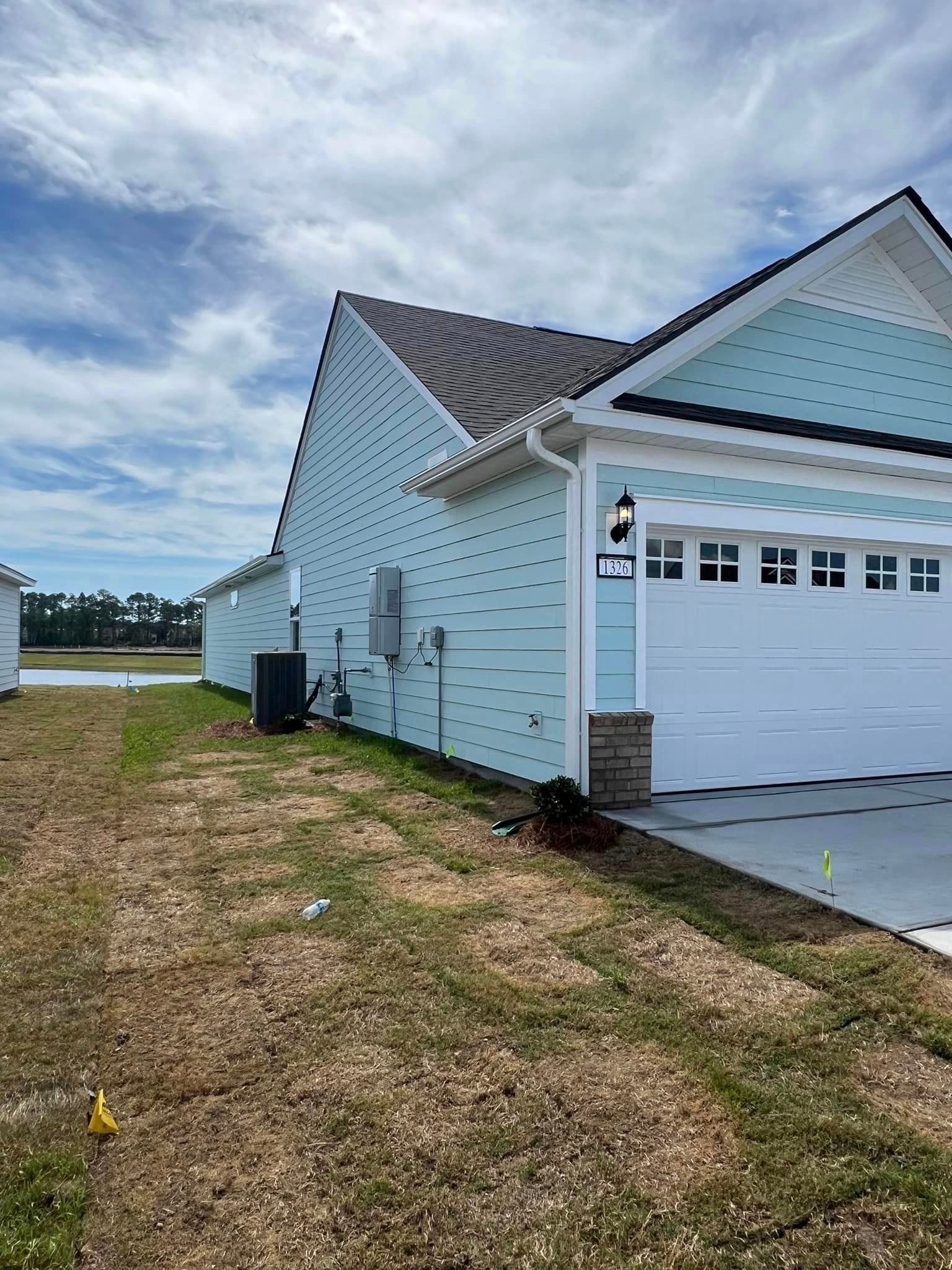 A house with a blue siding, a white garage door and best gutter installer in Coastal Carolina