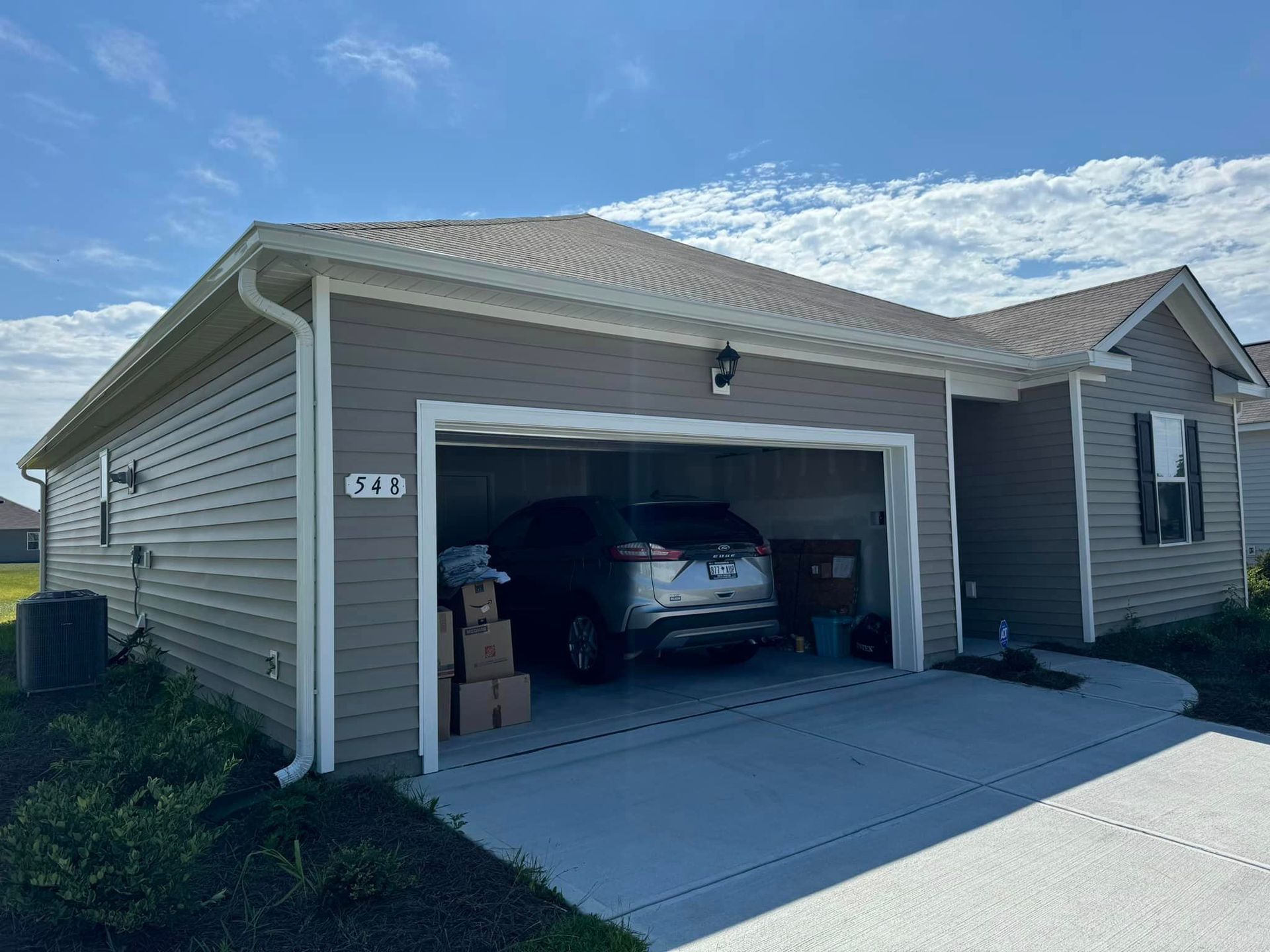 A car is parked in a garage next to a house with gutter in Galivants Ferry.