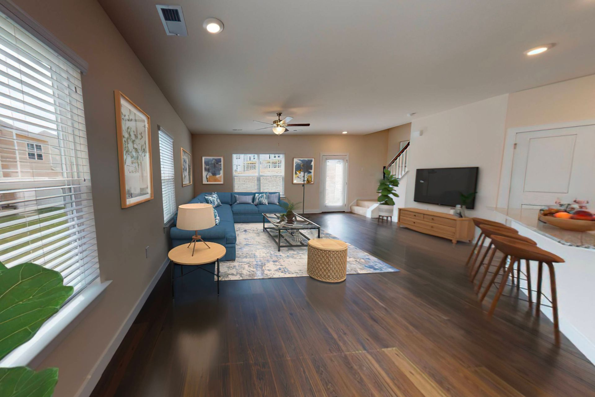 image of the first floor of the Wren 3 bedroom, 2.5 bath townhouse for rent at Towns at Swift Creek with modern living room furniture and barstools at the kitchen counter.