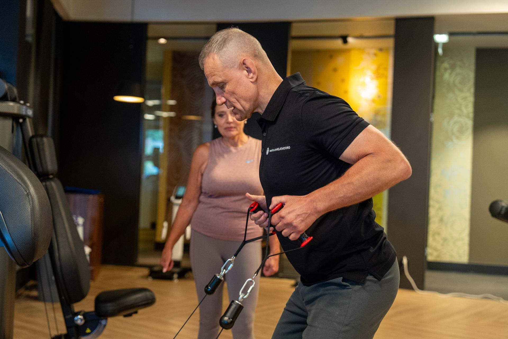 Een man en een vrouw doen oefeningen in een sportschool.