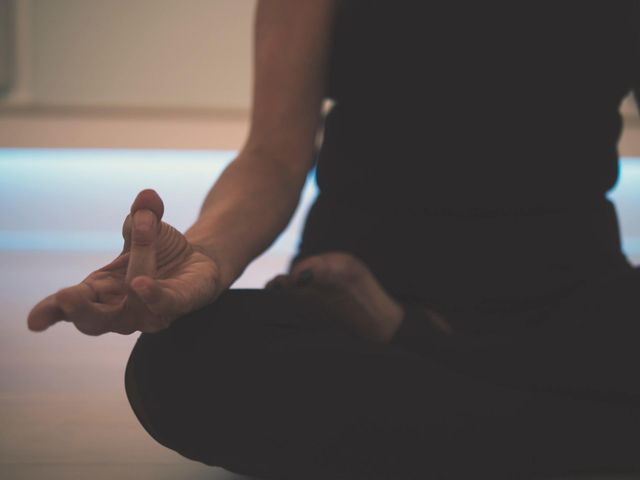 Een vrouw zit in de lotushouding met haar handen in een meditatiehouding.