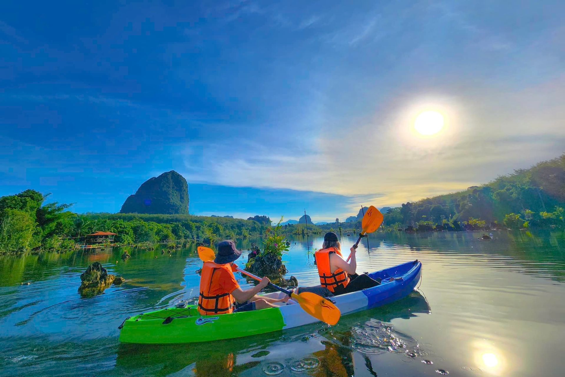 A couple of people are riding kayaks on a lake.