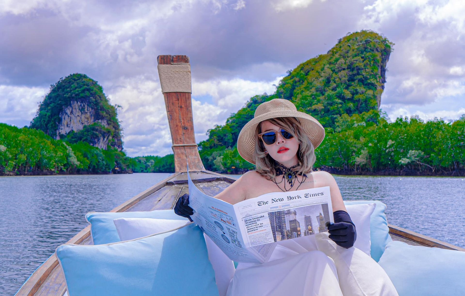 A woman is sitting on a boat reading a newspaper.