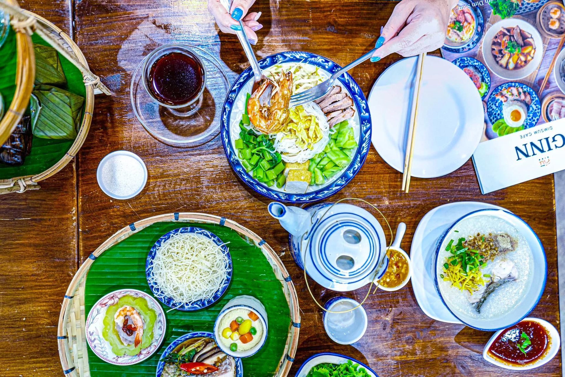 A table topped with plates of food and chopsticks.