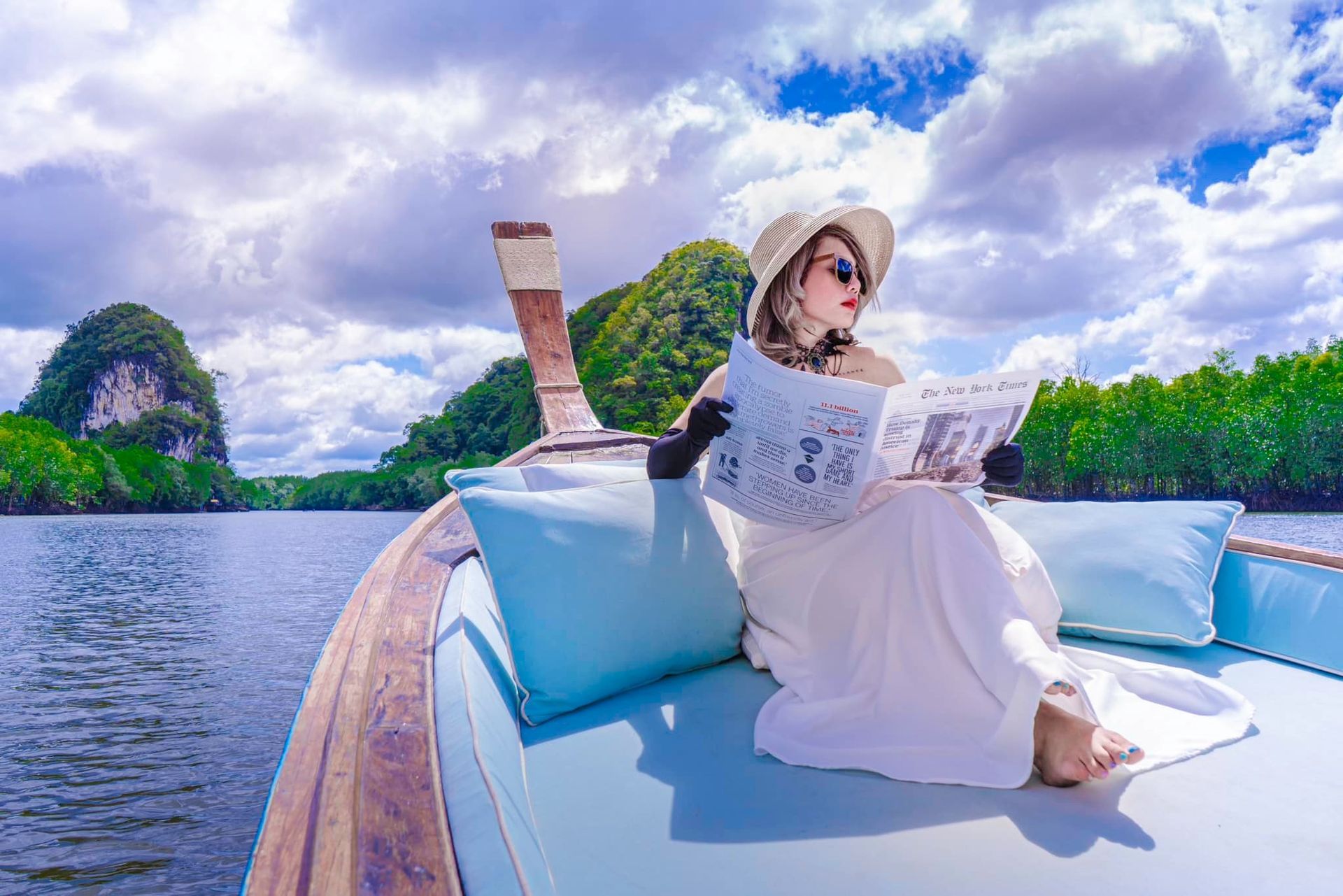 A woman is sitting on a boat reading a magazine.