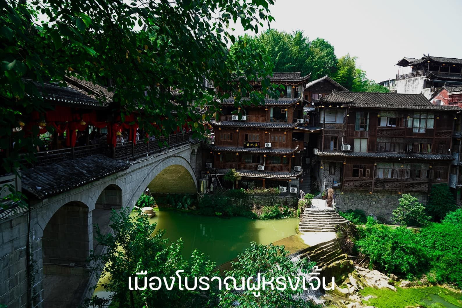 A bridge over a river surrounded by buildings and trees