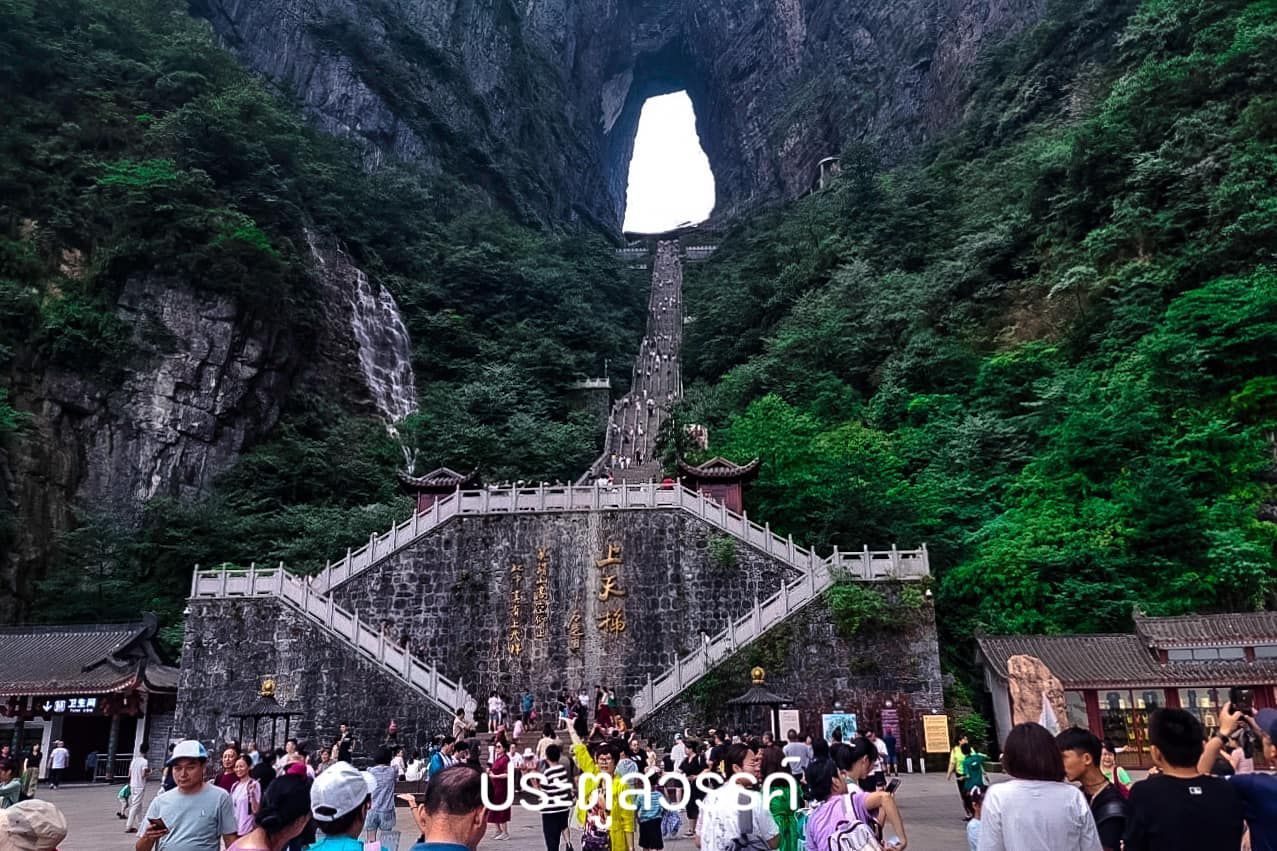 A group of people are standing in front of a mountain.