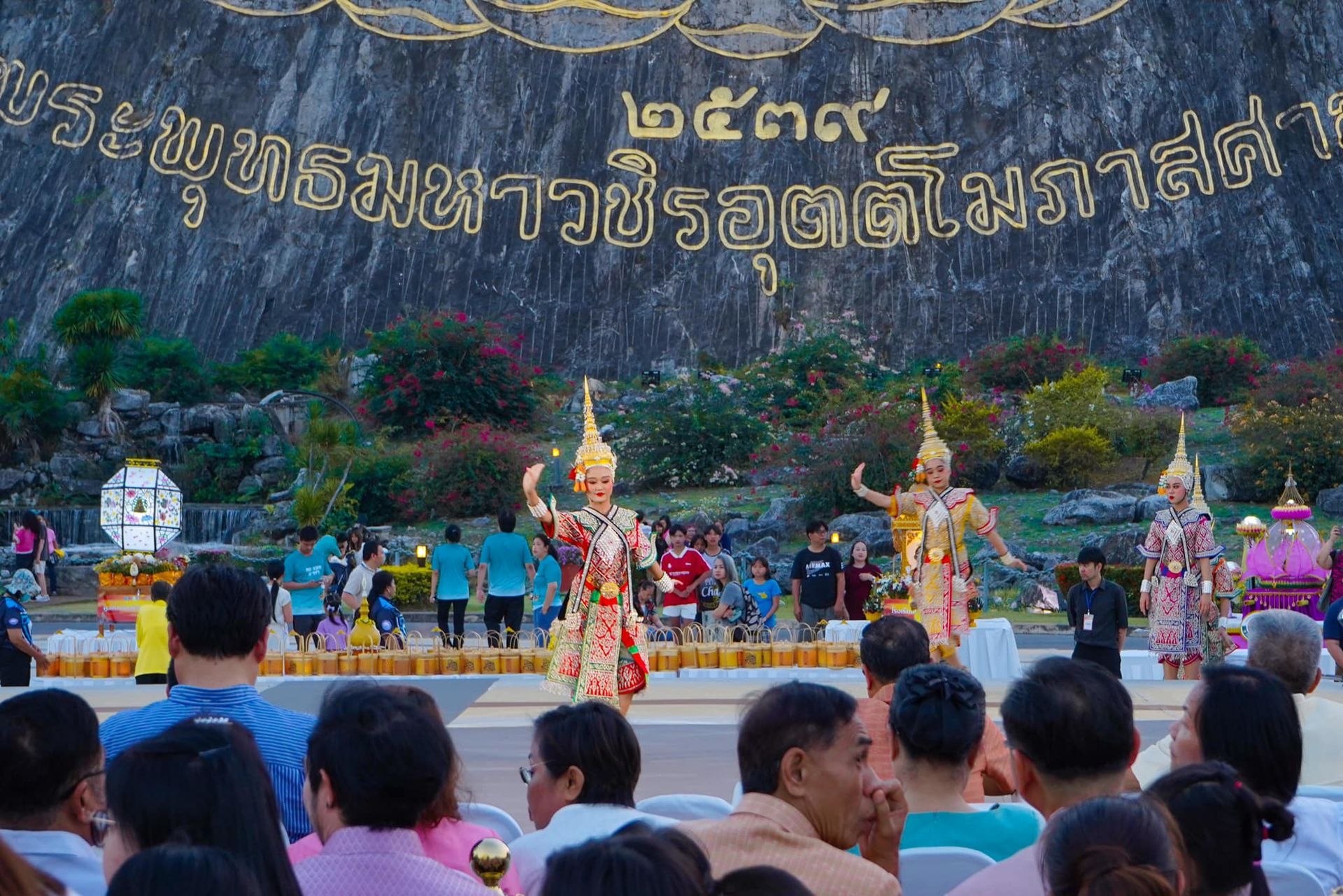 A crowd of people are watching a performance in a park.