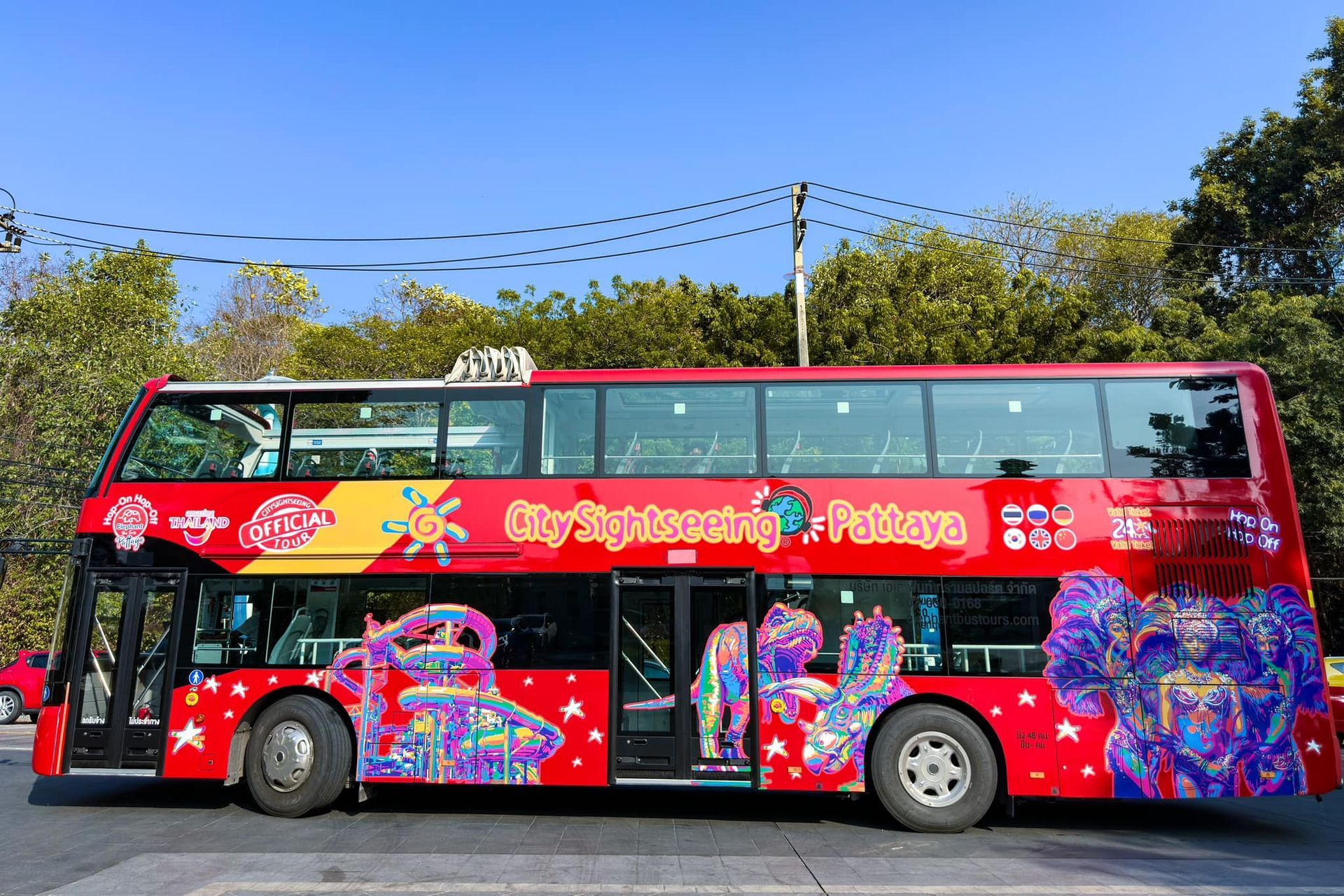 A red double decker bus is parked on the side of the road.