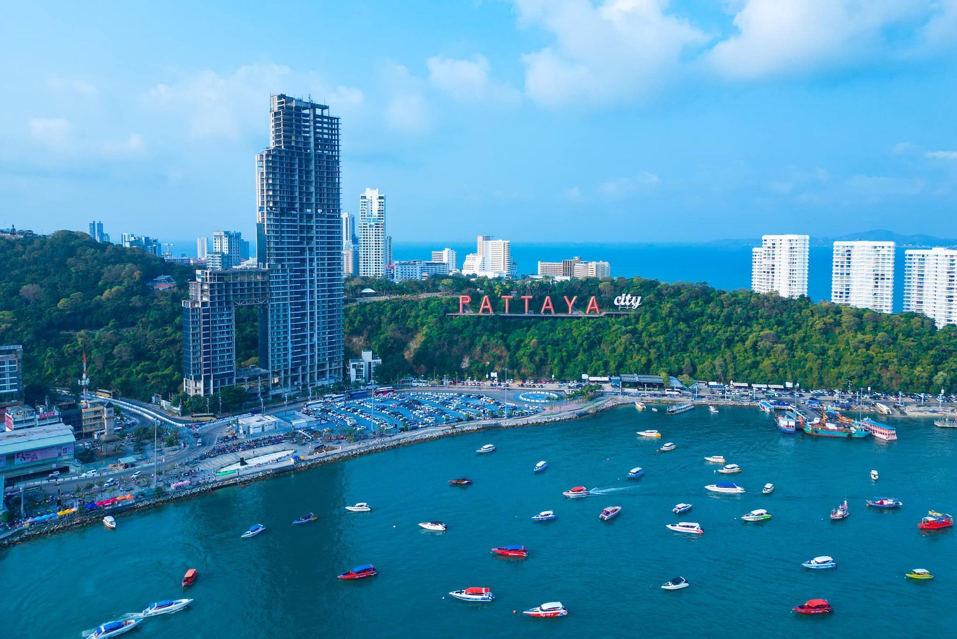 A large body of water with boats in it and a city in the background.