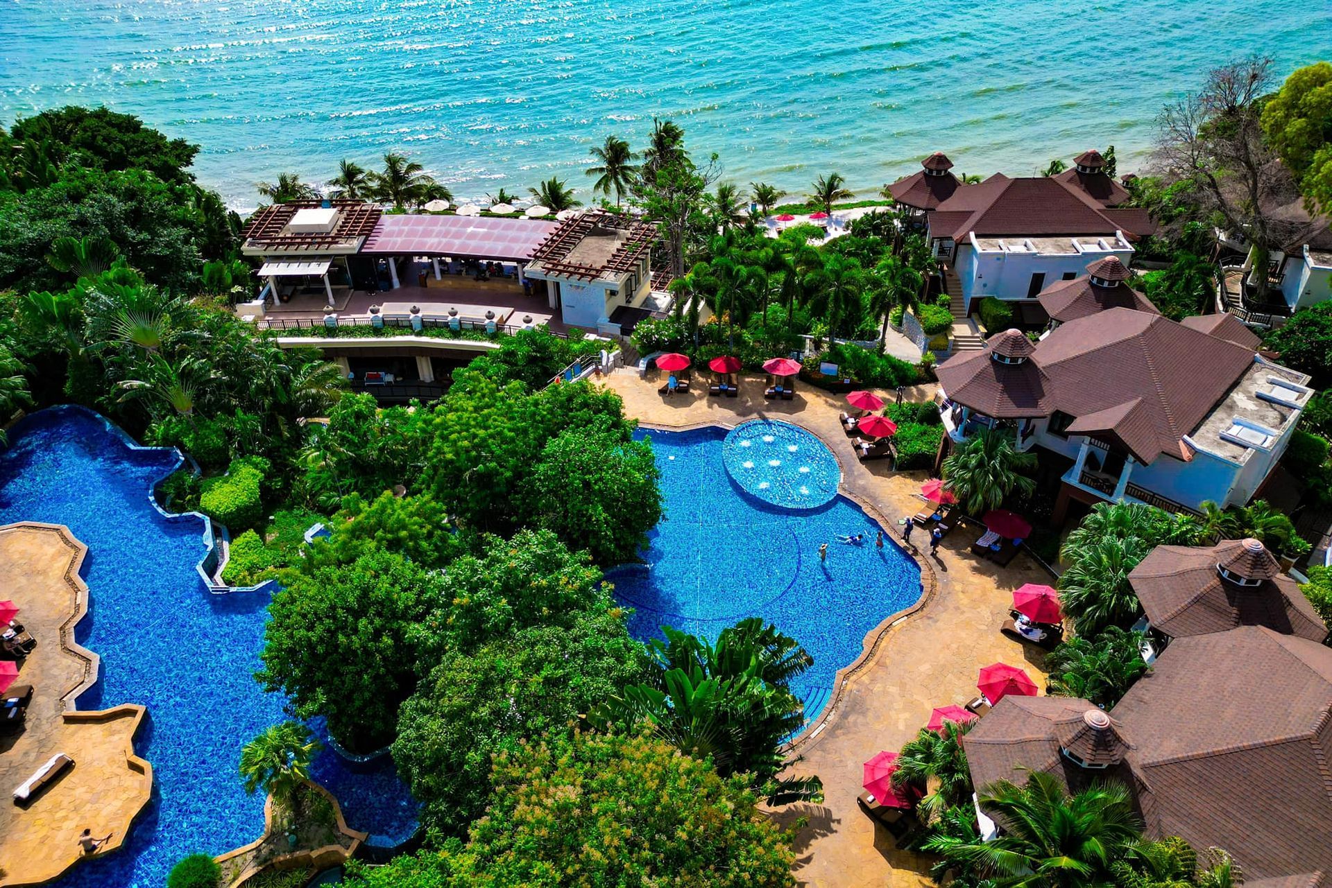 An aerial view of a resort with a large swimming pool
