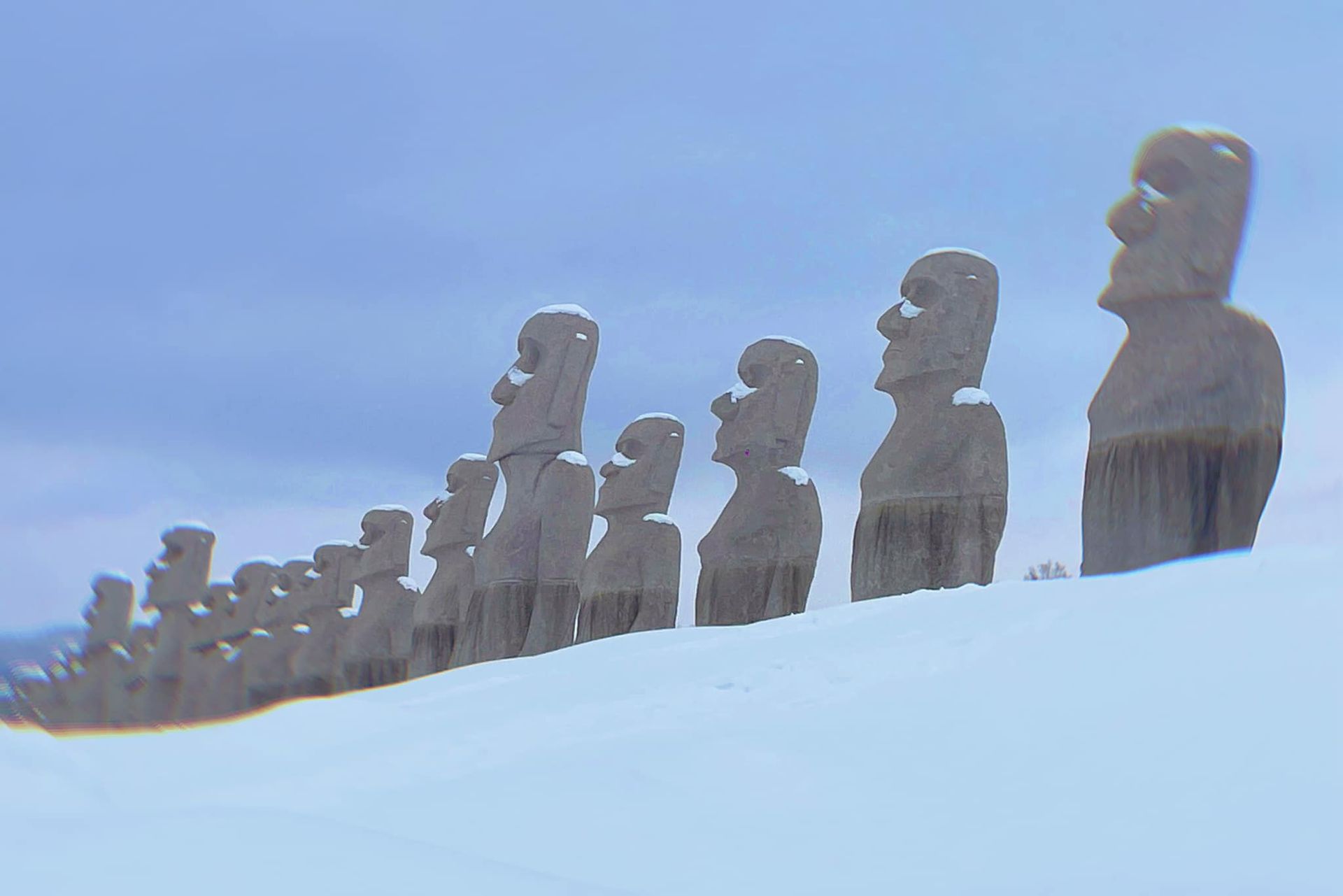 A row of statues on top of a snow covered hill