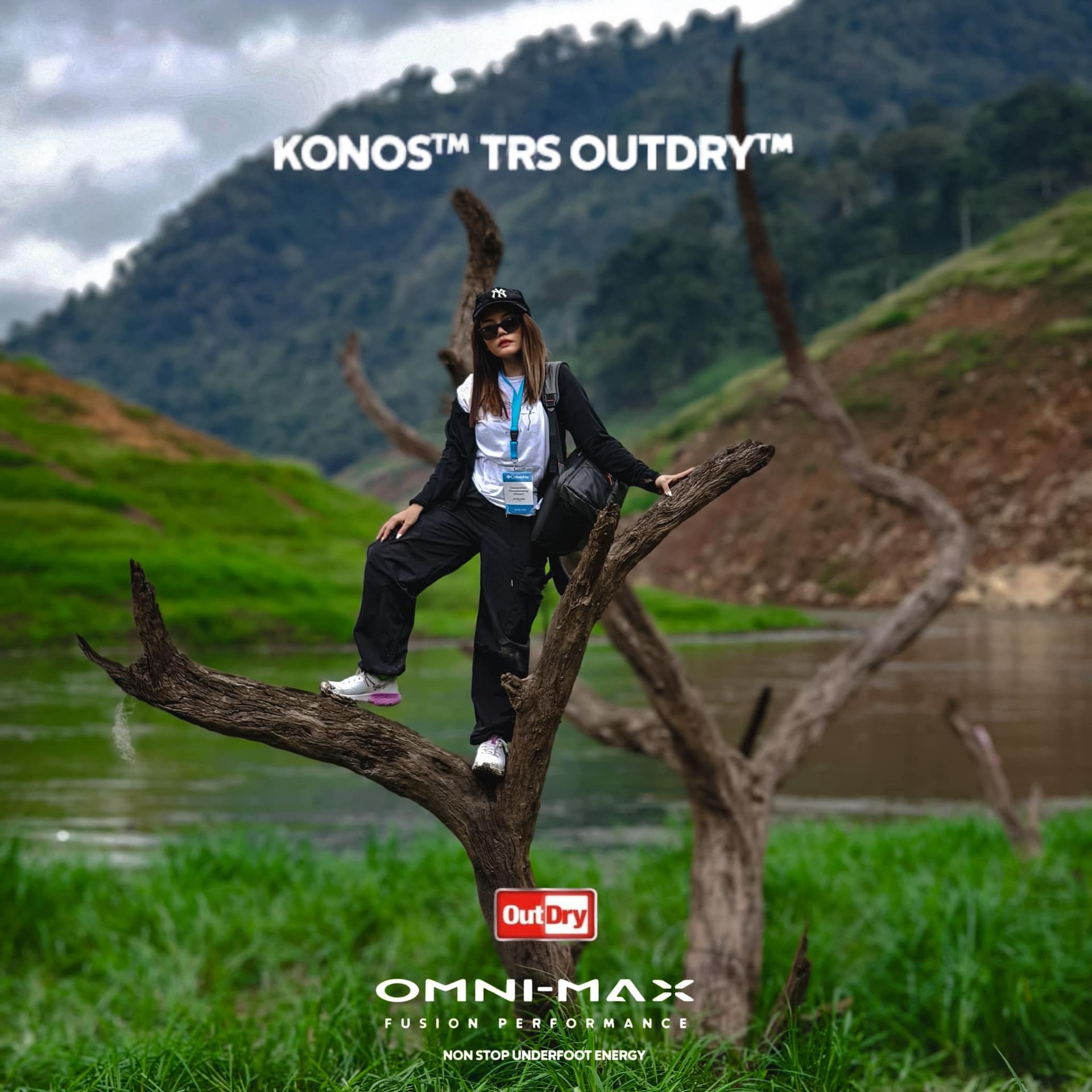 A woman is standing on a tree branch overlooking a lake.