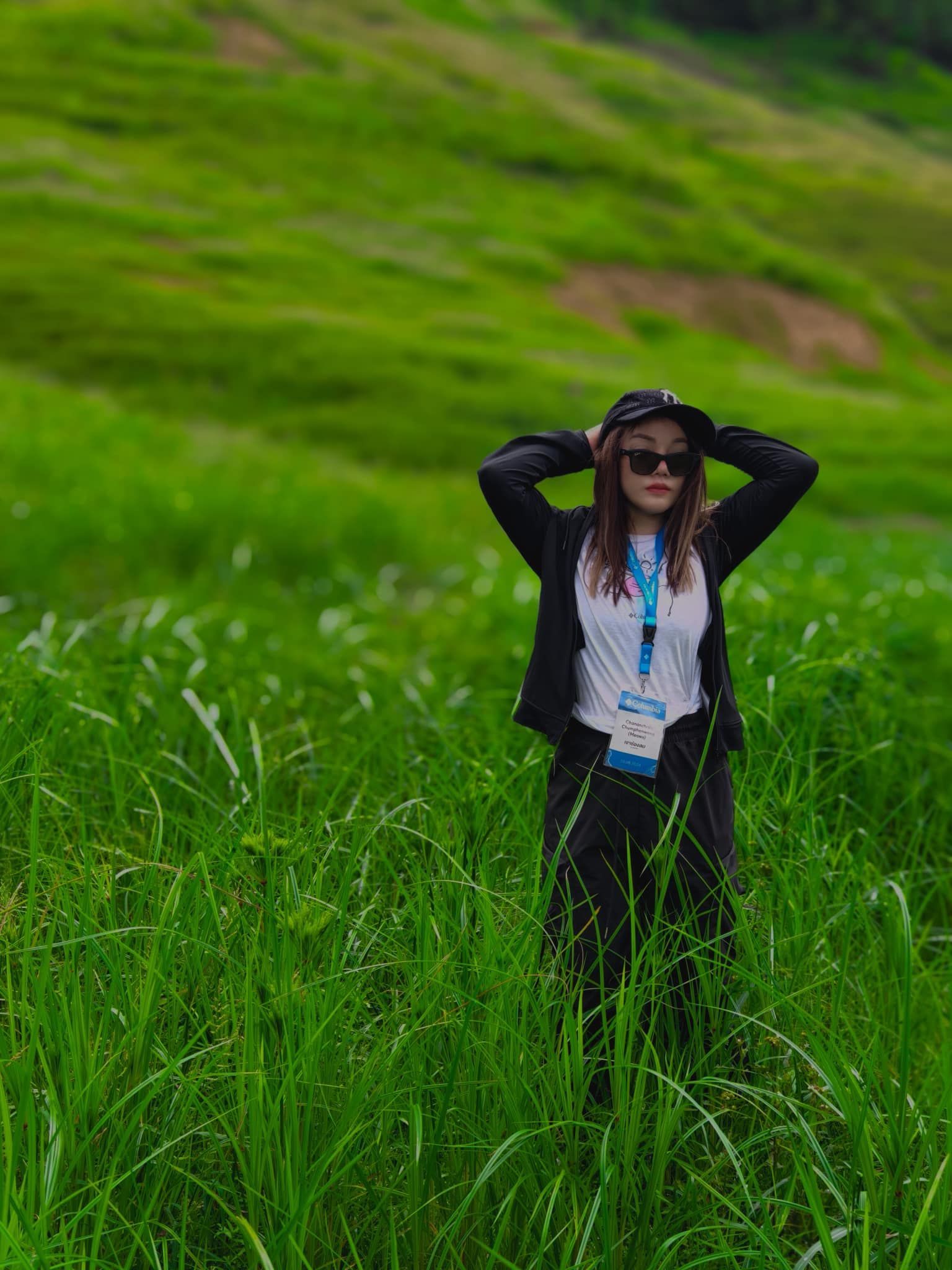 A woman is standing in a field of tall grass.