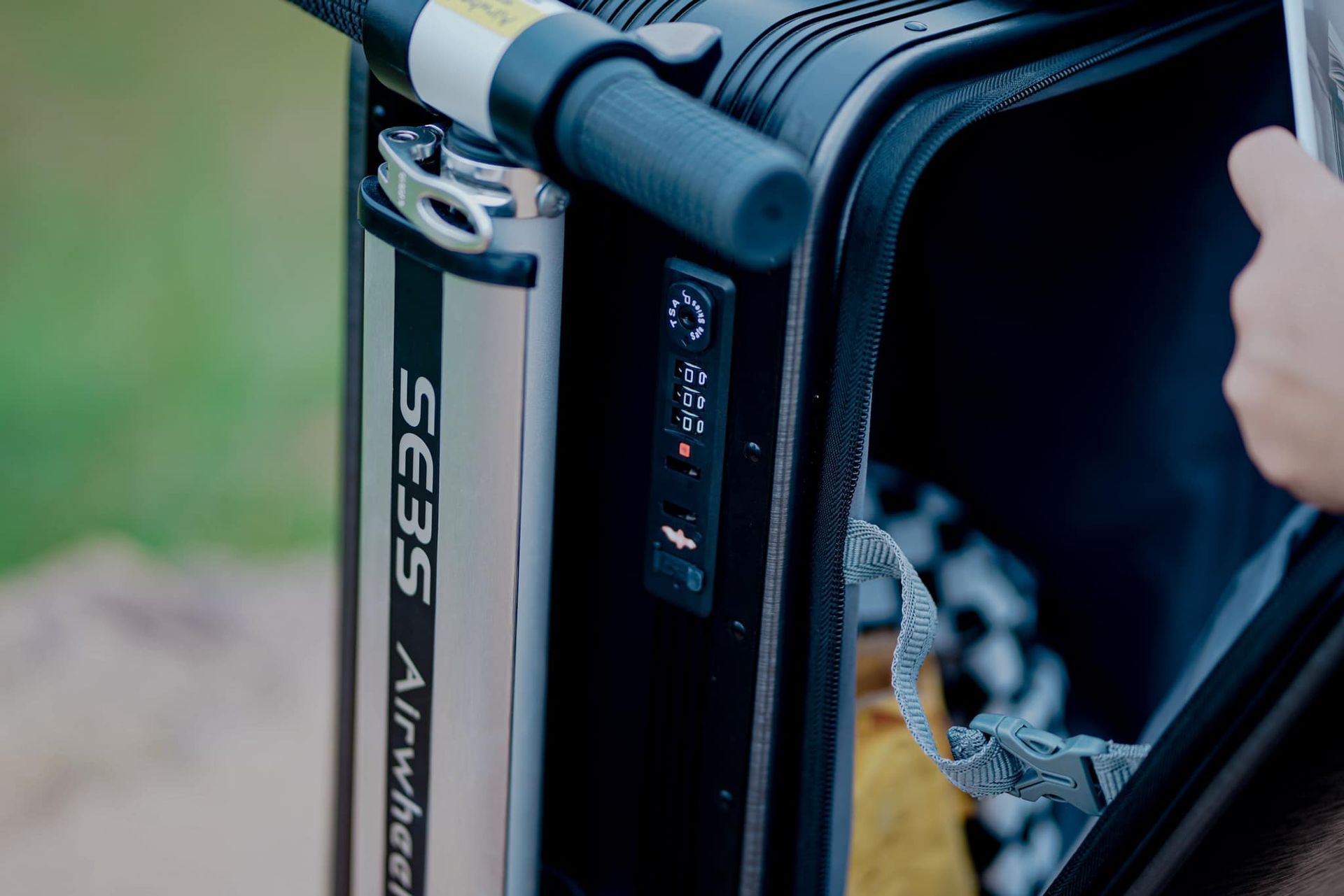 A person is putting something in a suitcase.