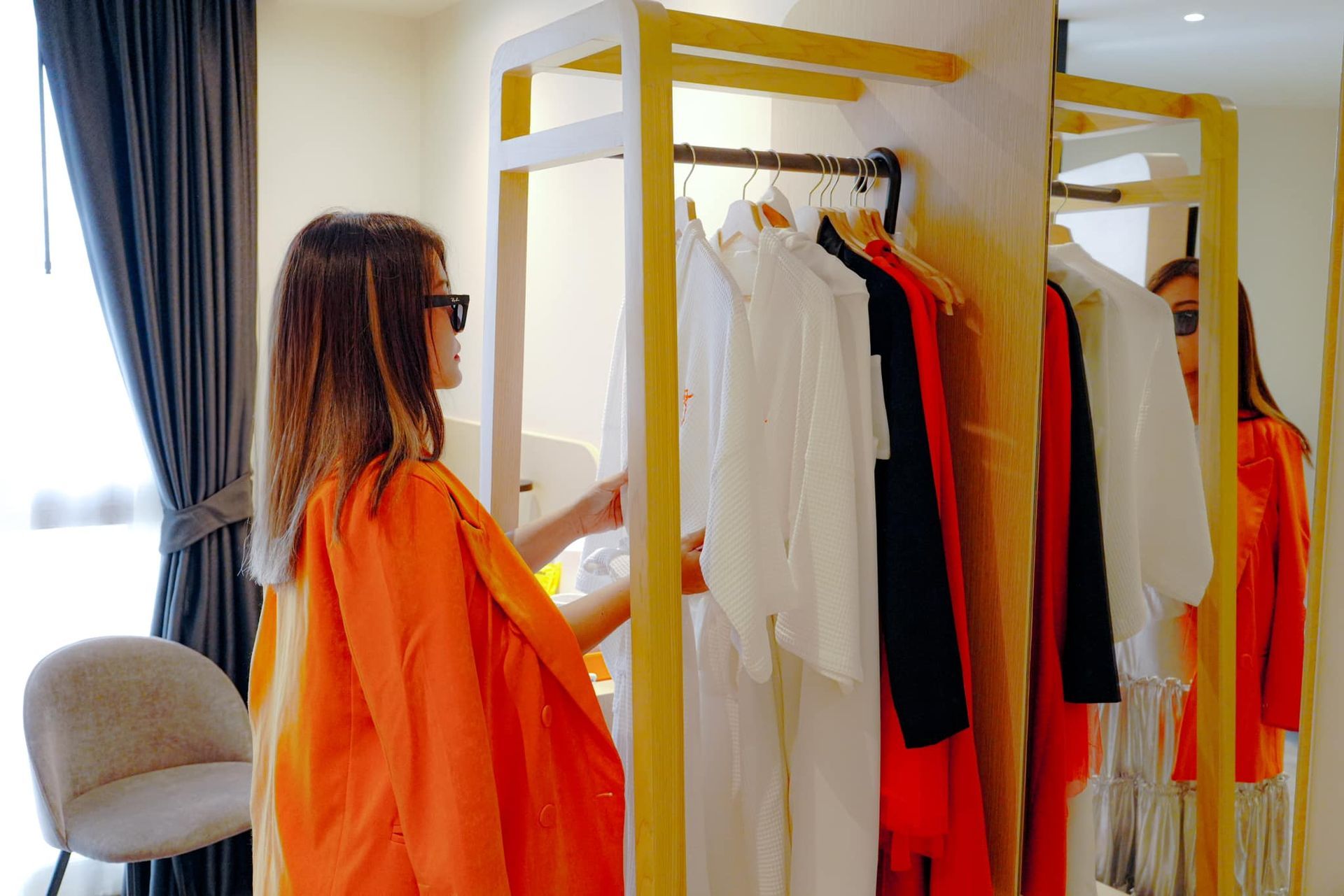 A woman is standing in front of a closet full of clothes.