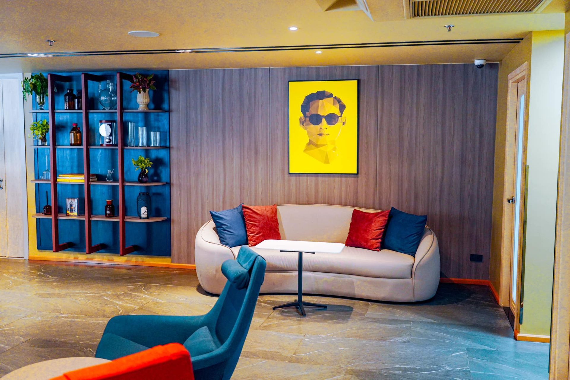A living room with a couch , chairs , a table and a painting on the wall.