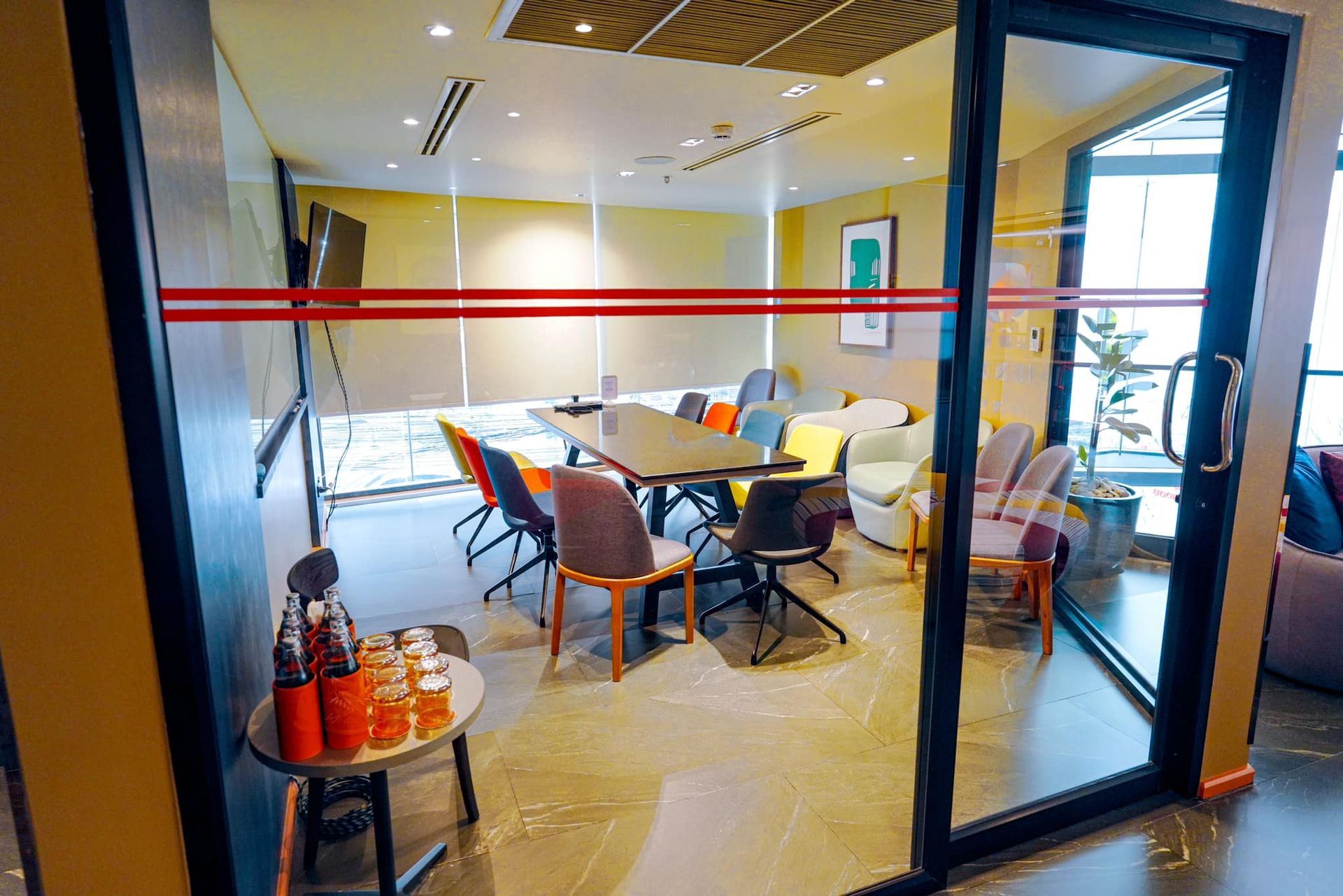A conference room with a table and chairs and a glass door.