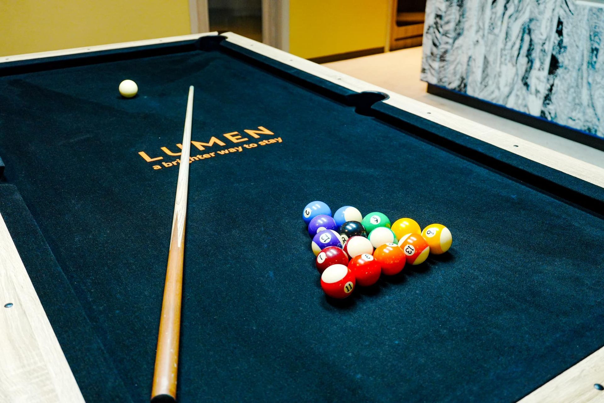 A pool table with the word lumen on it