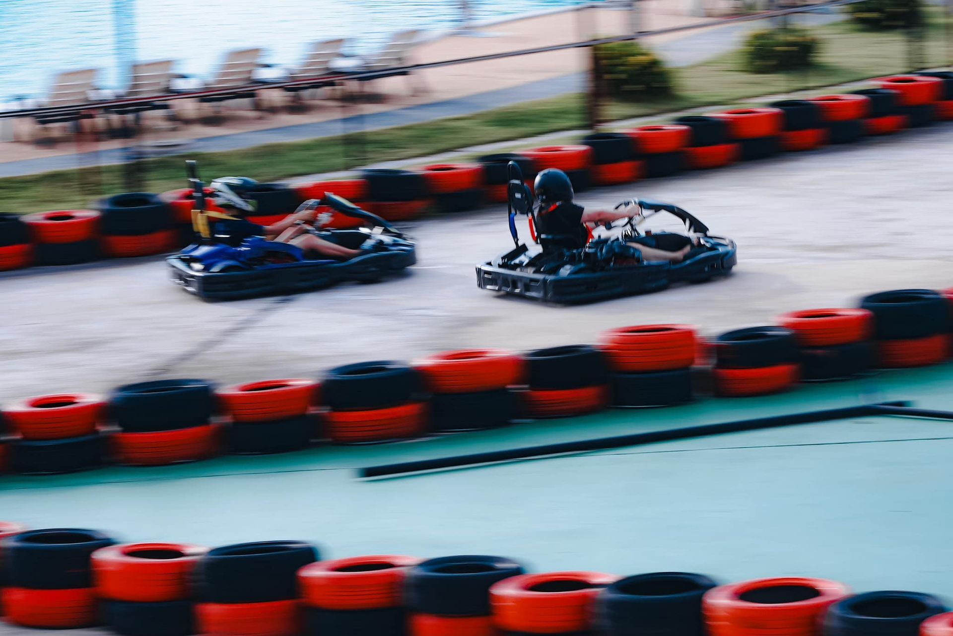 A group of people are riding go karts on a track.