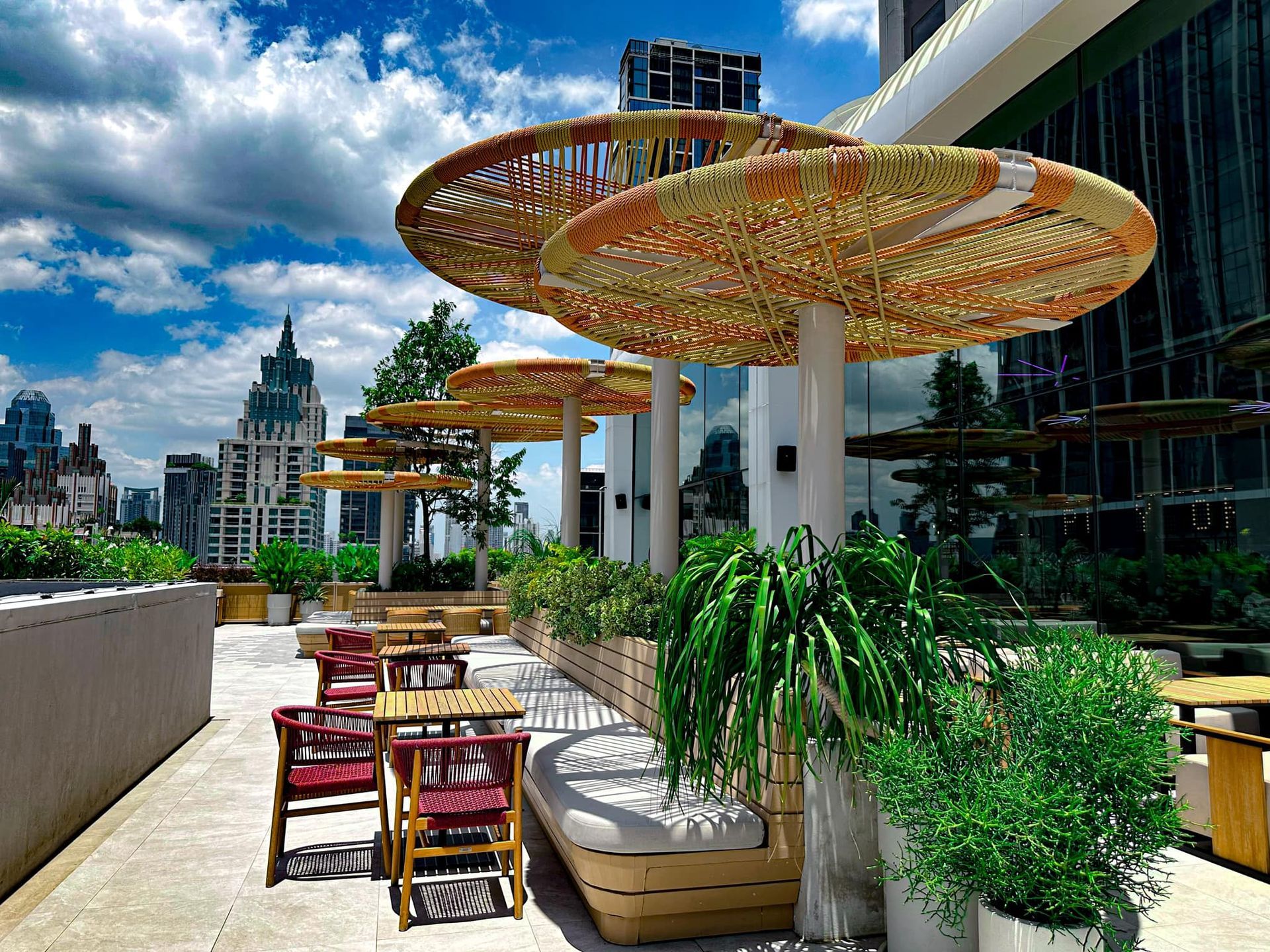 A rooftop patio with tables and chairs and umbrellas