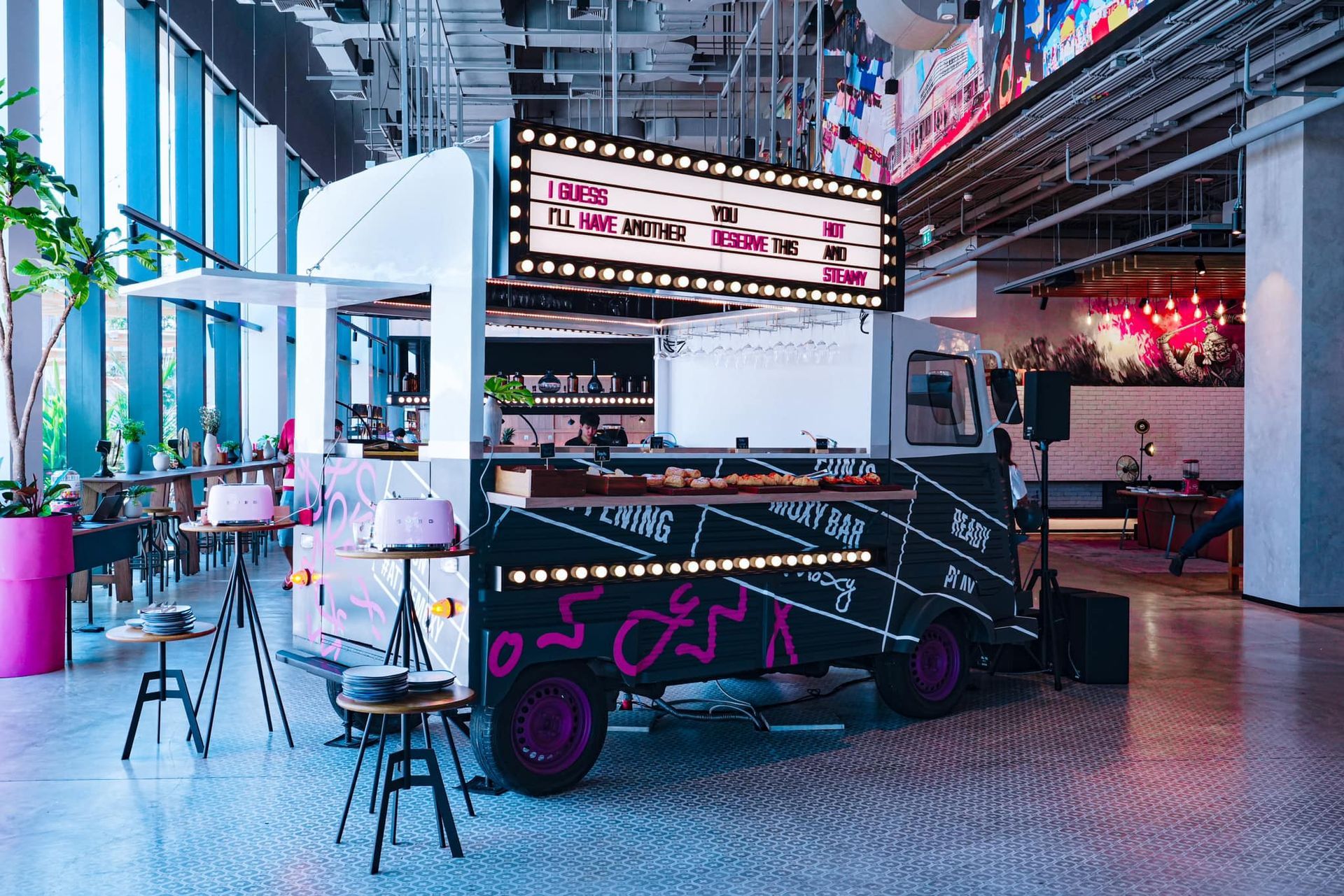 A food truck is parked in the middle of a restaurant.