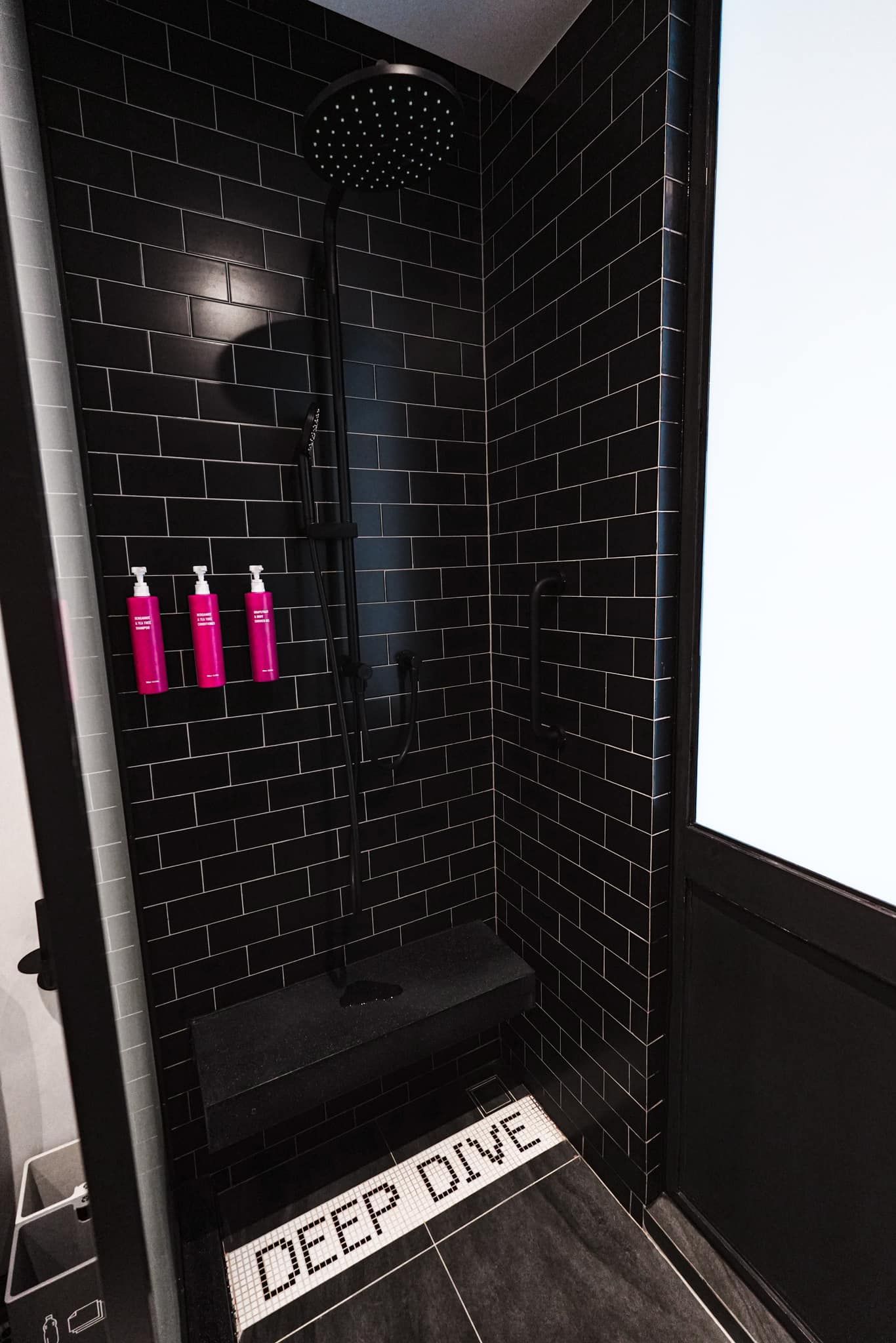A bathroom with a shower and a rug that says `` deep dive ''.