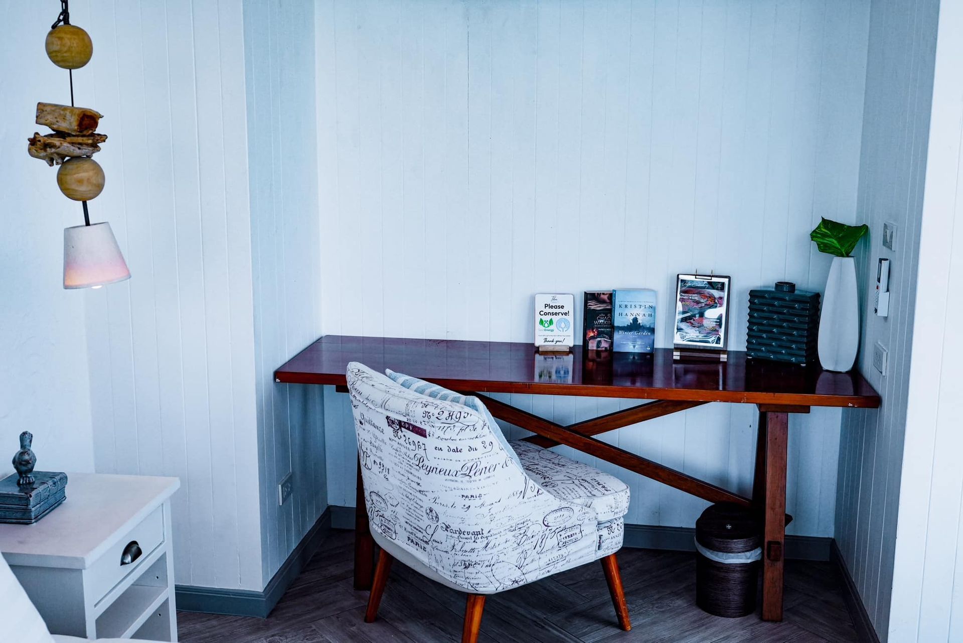 There is a chair and a desk in the corner of the room.
