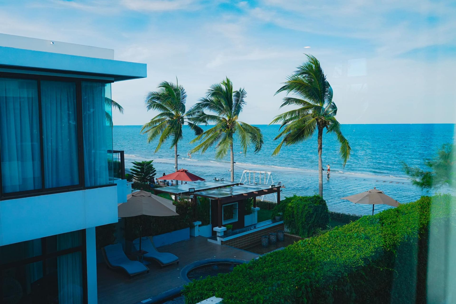 A house with a view of the ocean and palm trees.